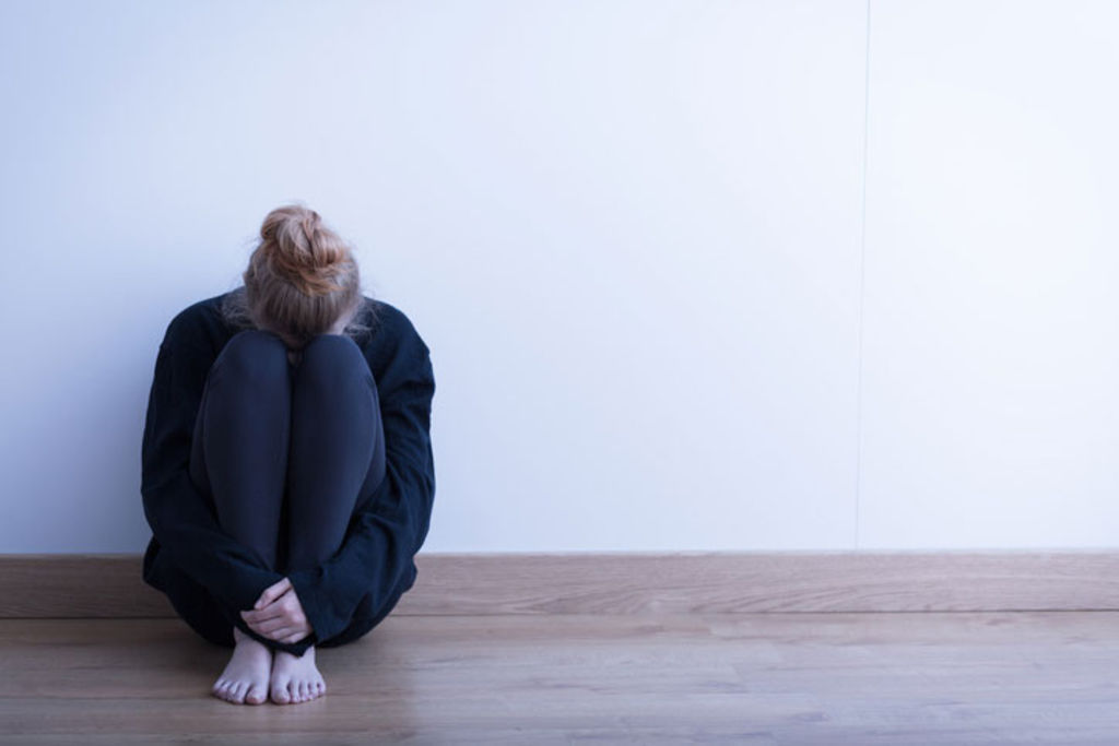 femme assise contre un mur